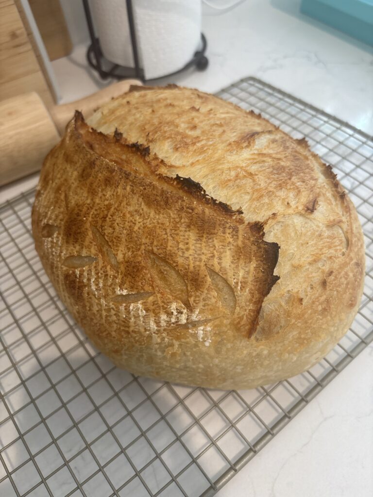Homemade sourdough bread with golden crust cooling on a wire rack