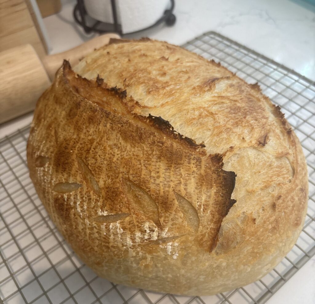 Homemade sourdough bread with golden crust cooling on a wire rack
